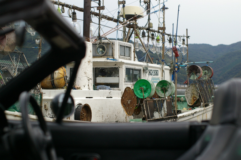 海への旅から帰った漁船と、旅に出ているロードスター