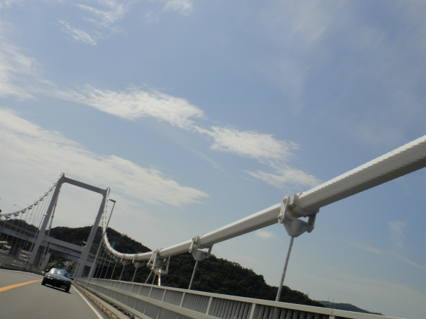 青空を拝みながら白い橋を渡る